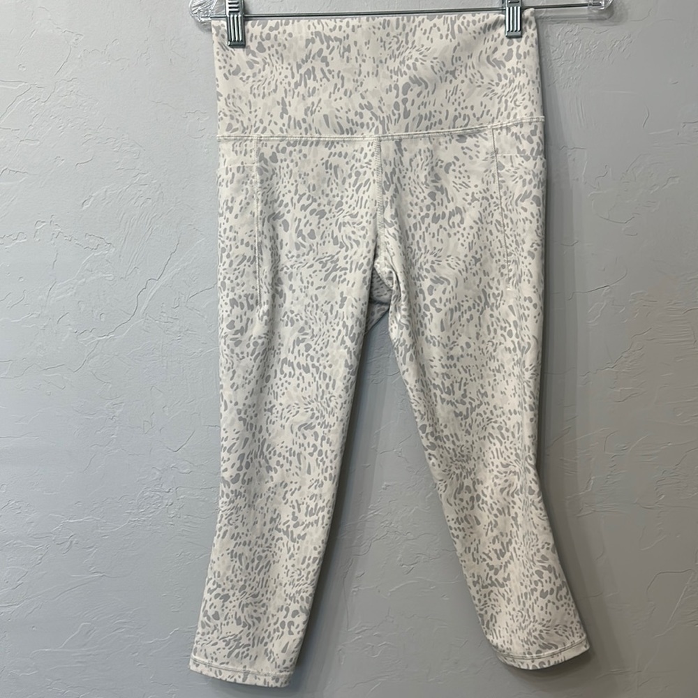 Athleta salutation stash pocket II print Capri leggings size small.